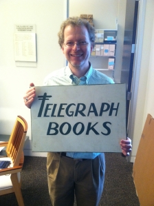 John Pollack proudly holding an artifact of the Telegraph Books collection: a hand-painted sign!